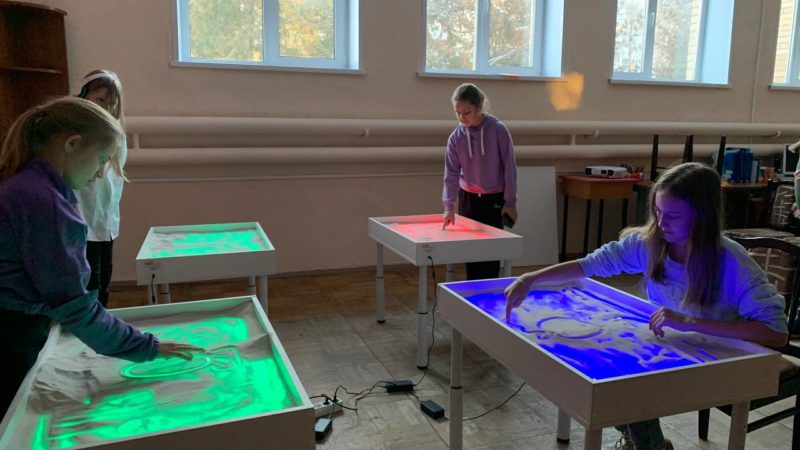 Юные ружане рисовали песком картинку из мультфильма