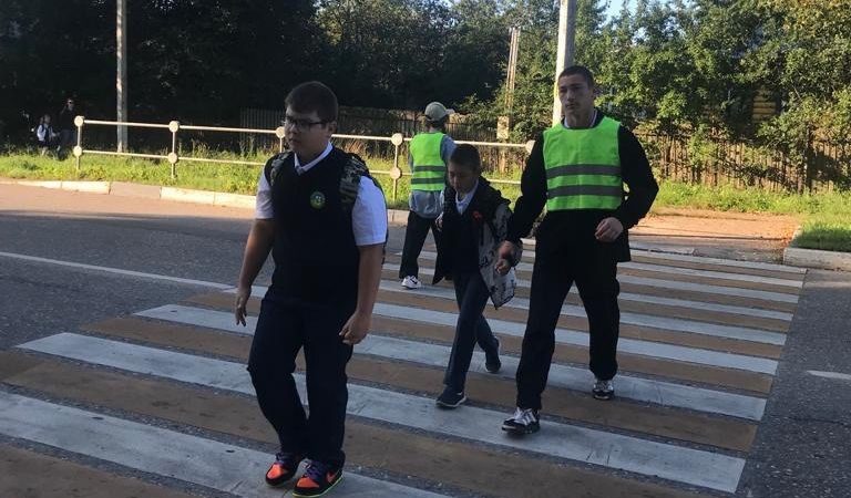 Младшеклассникам помогают переходить дорогу